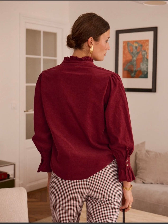 Blouse unie à col volanté et manches bouffantes. Bordeaux